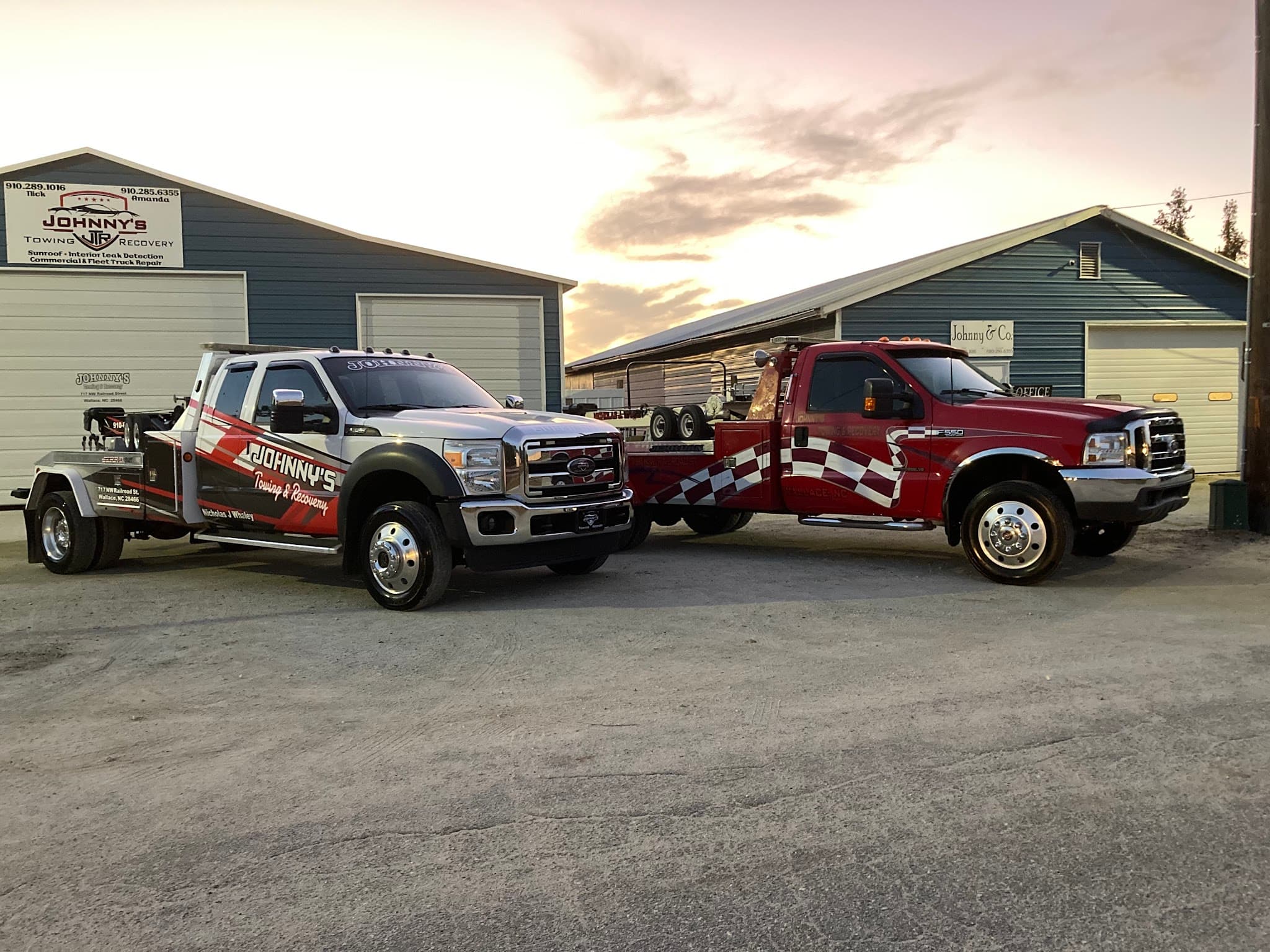 Johnny's Towing & Recovery trucks at the shop in Wallace, NC at sunset