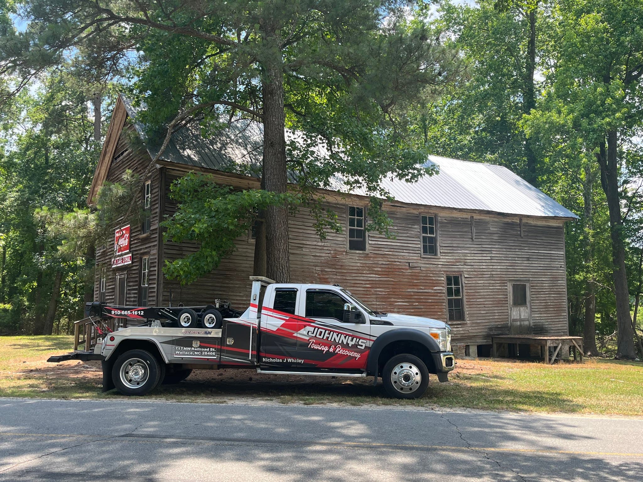 Johnny's Towing & Recovery truck parked in front of a historic Wallace, NC landmark